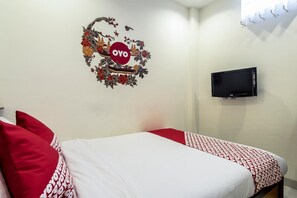 A hotel room with a bed, pillows, a TV, and a wall decoration. - Harmony Beach (Nessebar)