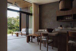 Una cocina moderna con una isla grande, mobiliario de madera y vistas a zonas verdes.