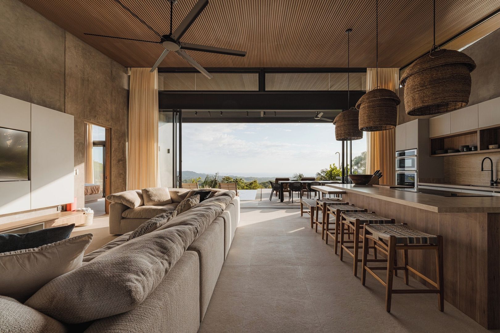A modern interior with a sofa, dining area, and kitchen.