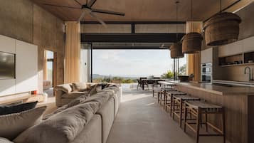 A modern interior with a sofa, dining area, and kitchen.