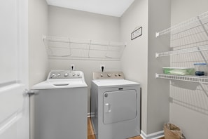 A laundry room with two washing machines, a drying rack, and storage shelves. - Beautiful 3-bedroom house pleasant Grove City (Grove City)