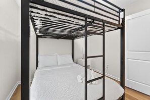 A bunk bed with a metal frame, white bedding, and a bedside table with a lamp. - Beautiful 3-bedroom house pleasant Grove City (Grove City)