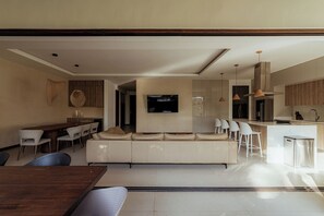 Un salon moderne comprenant un canapé, un coin repas et une cuisine.