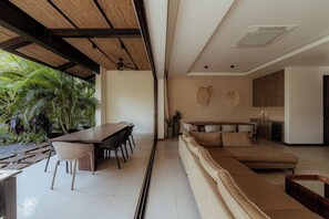 Un intérieur moderne comprenant un coin repas, un canapé et une cuisine.