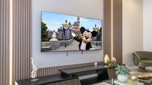 Ein Flachbildfernseher an der Wand, auf dem eine Disney-Figur zu sehen ist.