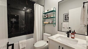Un bagno moderno con vasca, servizi igienici e un mobile vanità con specchio.