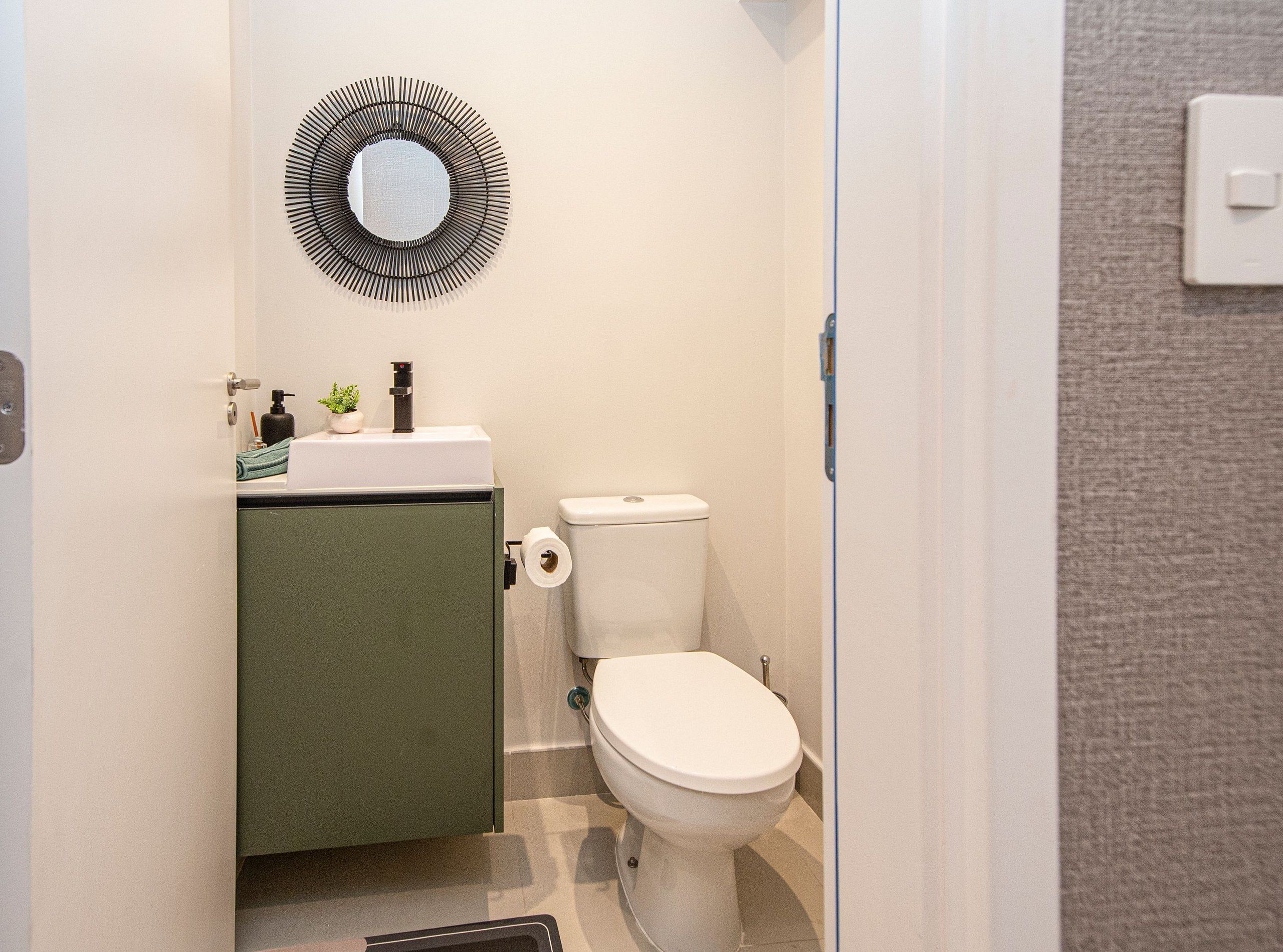 Un baño pequeño con inodoro, lavamanos y espejo.