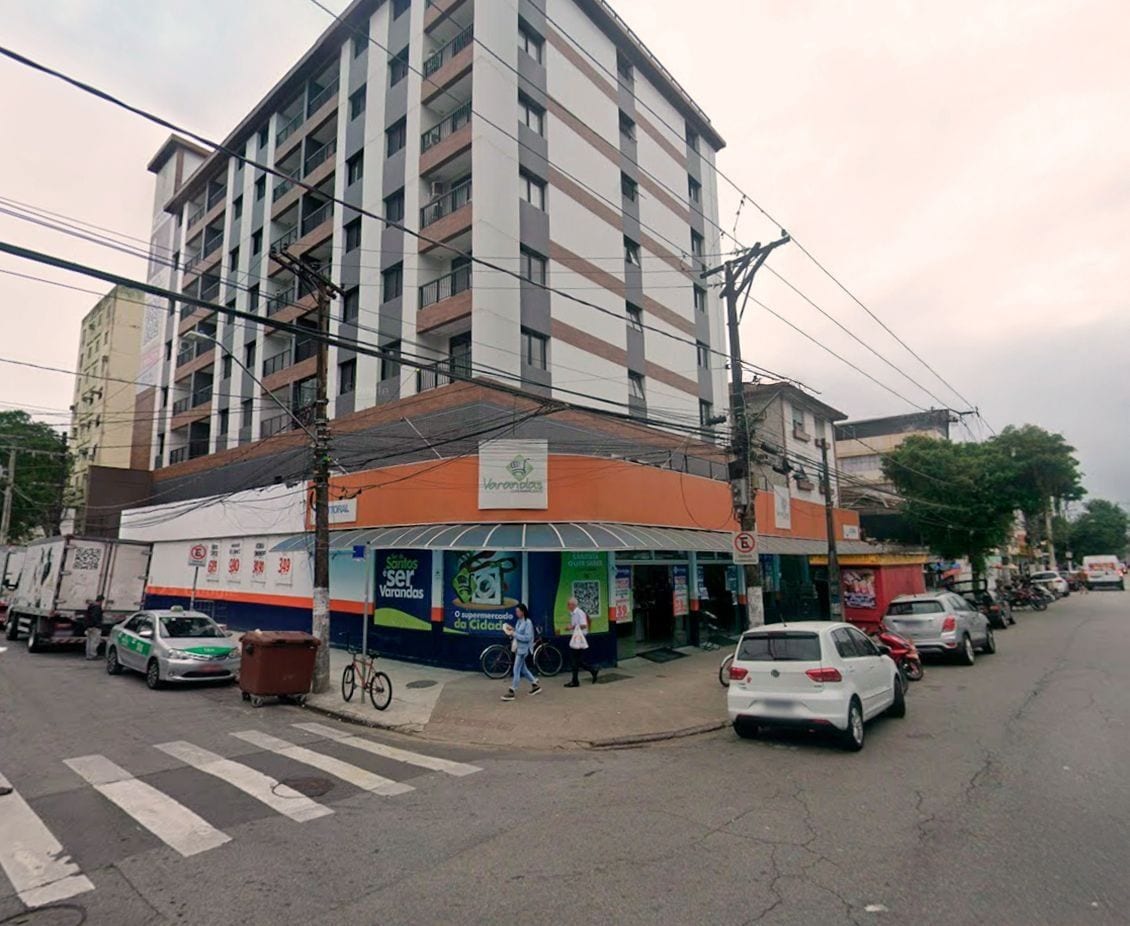 A multi-story building with a commercial ground floor featuring a pharmacy and a café.