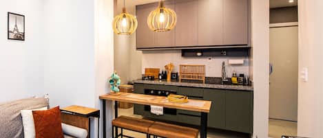 A modern kitchen with a central island, pendant lighting, and a dining bench.