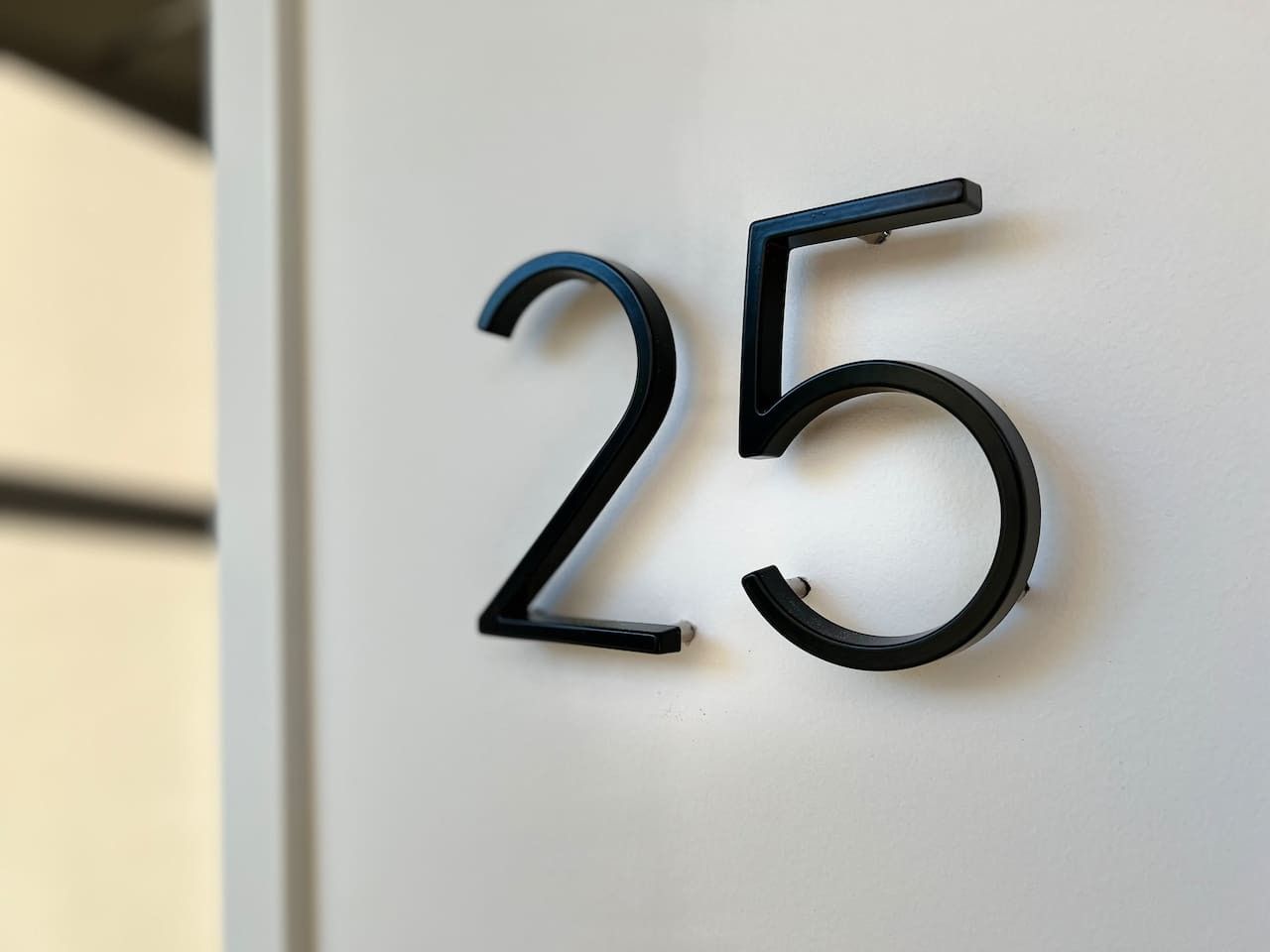 Die Zahl '25' an einer Wand, vermutlich eine Zimmernummer.