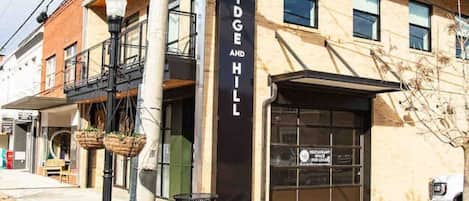 A building with a sign that reads 'BRIDGE AND HILL' and a sign for 'MARKET SHOPPS' indicating nearby shopping.
