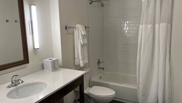 A bathroom with a white sink, toilet, and shower curtain.