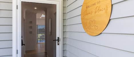 A doorway leading to a hallway with a welcome sign on the wall.