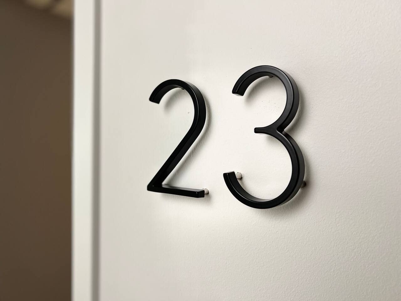 Un letrero con el número 23 fijado a la pared.