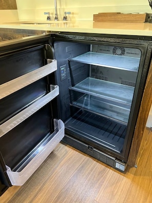 An empty refrigerator with multiple shelves and a control panel.