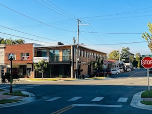 A street intersection with a stop sign, a building with a sign for a restaurant, and a clear blue sky.
