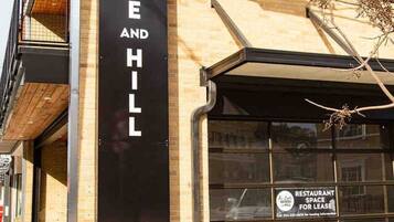 Um edifício com uma placa que diz 'The Lofts at Bridge Hill' e uma placa indicando 'RESTAURANT SPACE FOR LEASE'.