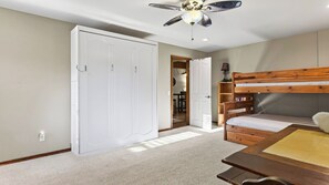 Ein Schlafzimmer mit einem Etagenbett, einem Kleiderschrank, einem Deckenventilator und einem Teppichboden.