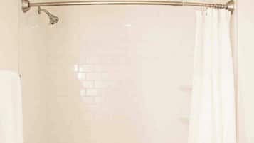 A bathroom with a bathtub, toilet, and a shower curtain.