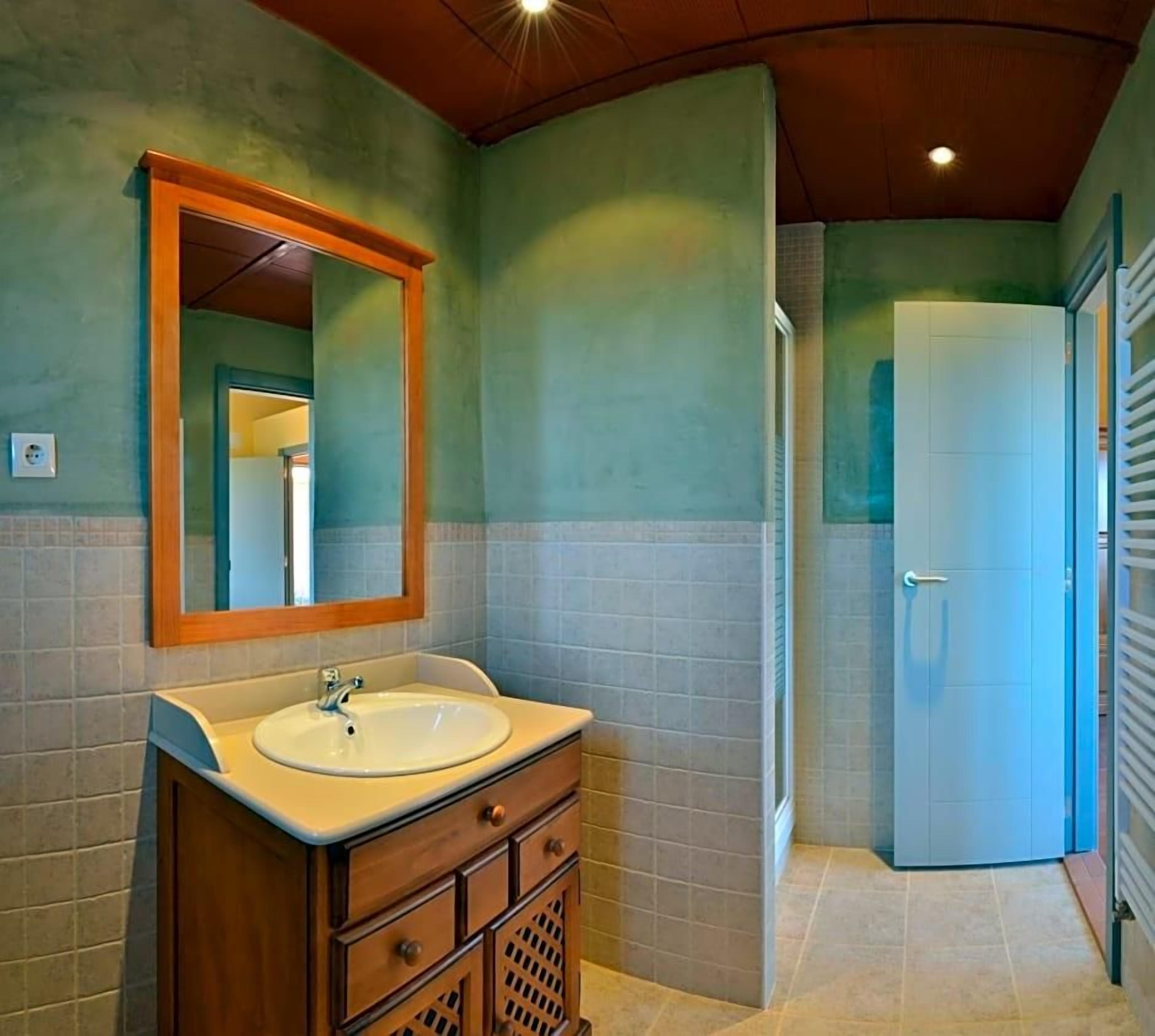 A bathroom with a sink, mirror, and cabinet.
