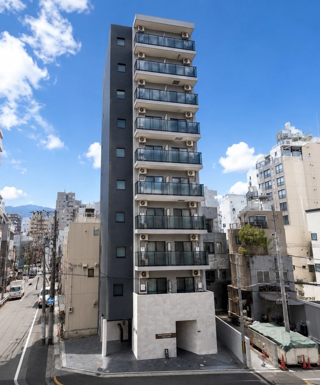 Un edificio de varios pisos con balcones, fachada plana y cielo despejado.