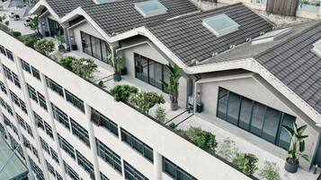 A modern building with multiple floors, large windows, and a flat roof with skylights.