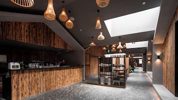 Decoração moderna com balcão de recepção, painéis de parede em bambu e diversos pendentes.