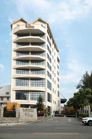 Ein mehrstöckiges Hotel mit modernem architektonischen Design, inklusive Balkonen und großen Fenstern.