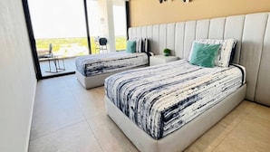 Quarto moderno com duas camas, varanda e vista.