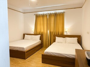 A room with two single beds, wooden headboards, and a curtain with a cut-out design. - Casa Verde:  Your Tropical Escape in SOV (Sosua)