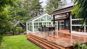 A modern house with a glass conservatory, wooden deck, and a barbecue area. - Cozy home in Kolind with private swimming pool, can be inside or outside (Kolind)