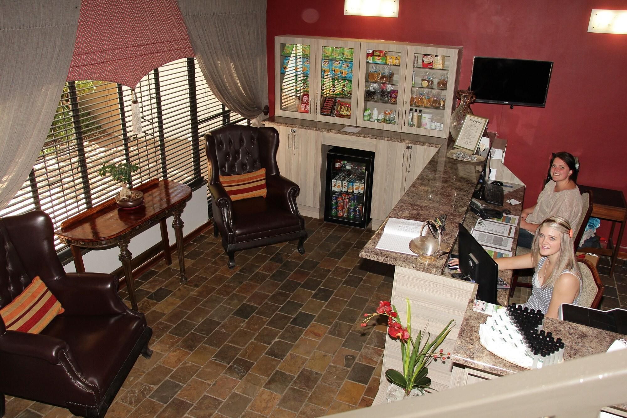 A hotel lobby with a fireplace, a reception desk, and a television mounted on the wall.