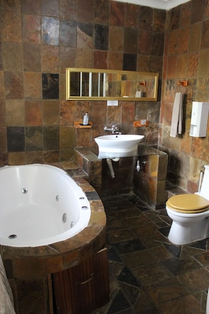 Un baño con bañera, lavabo e inodoro.