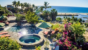 A pool area with a hot tub, lounge chairs, and potted plants. - Las Casitas (Todos Santos)