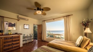 A room with a bed, a desk, and a view of the sea. - Las Casitas (Todos Santos)