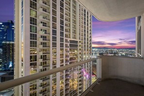 A high-rise building with multiple balconies and a cityscape view at dusk. - Strip View Suite|On LV Strip w/Balcony/LazyRiver (Las Vegas)