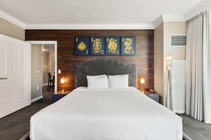 A hotel room with a large bed, a dark headboard, and a wall-mounted artwork of playing cards. - Strip View Suite|On LV Strip w/Balcony/LazyRiver (Las Vegas)