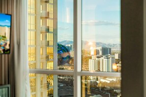 A high-rise building with multiple balconies and a view of a cityscape with mountains in the distance. - Strip View Suite|On LV Strip w/Balcony/LazyRiver (Las Vegas)