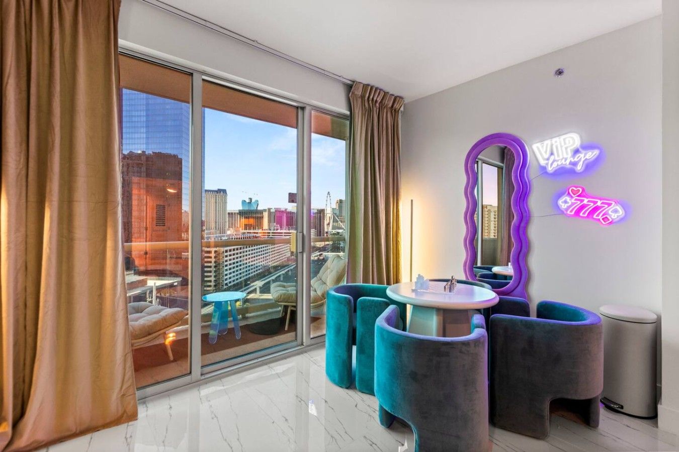 A modern hotel room with a large sliding glass door, a neon sign, and a city view.