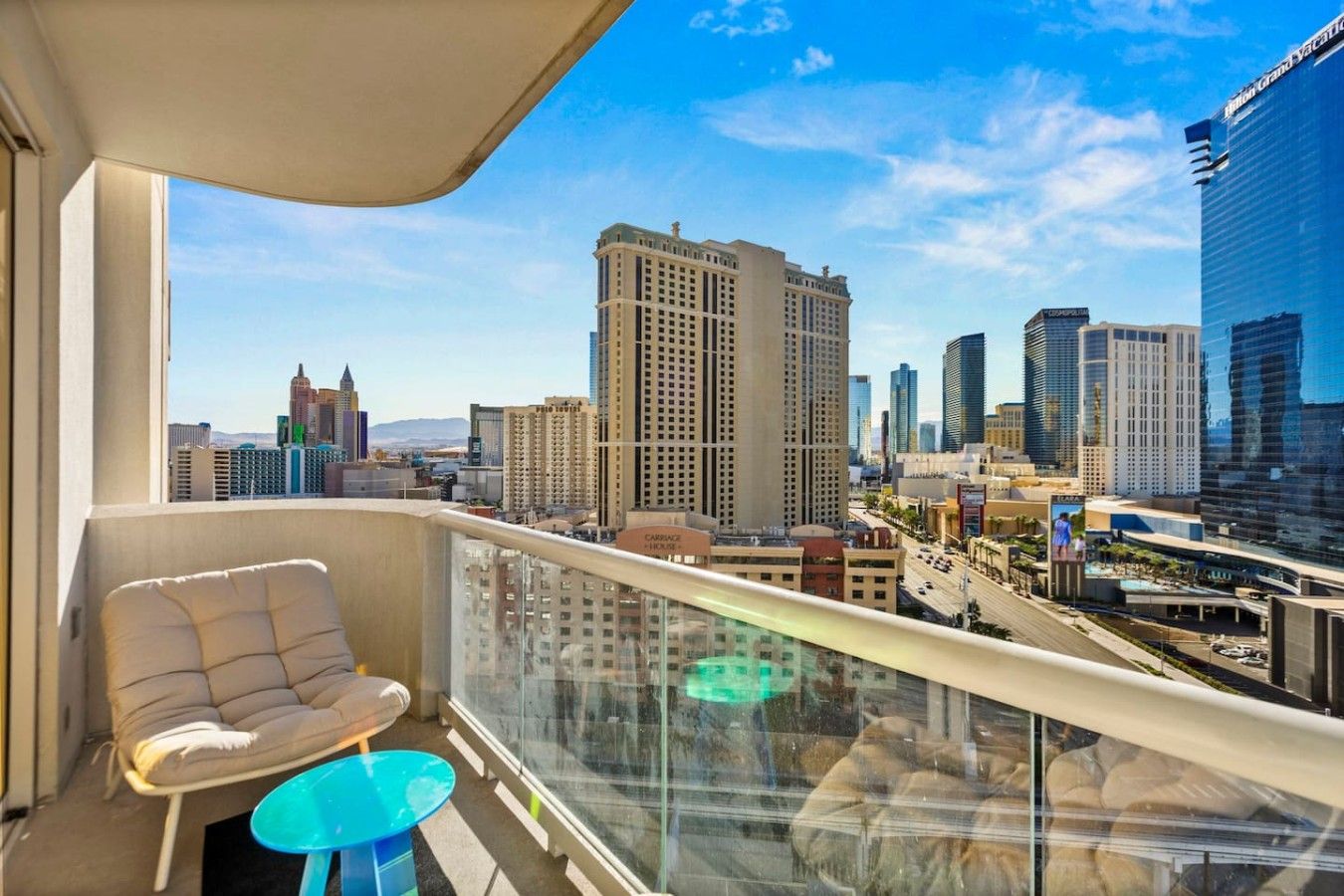 Un balcon avec vue sur la ville, une chaise et une petite table.