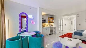 Uma sala de estar moderna com área de jantar, cozinha e quarto.