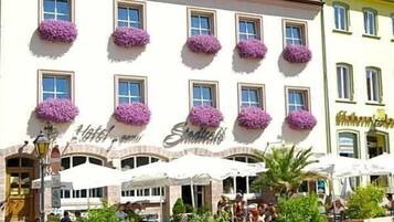 Ein Hotel mit mehreren Fenstern, Außenbereich zum Sitzen und einem Schild, das es als Hotel kennzeichnet.