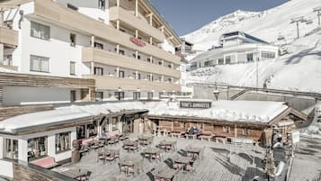 Un hotel con terraza exterior y un letrero que dice 'TONI'S ALMHÖTTE'.