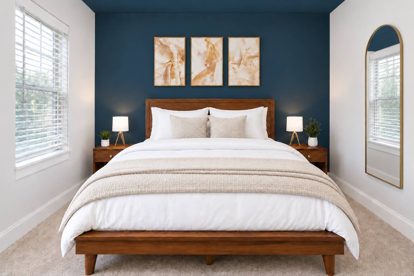 A bedroom with a wooden bed, white bedding, two bedside lamps, and abstract wall art.