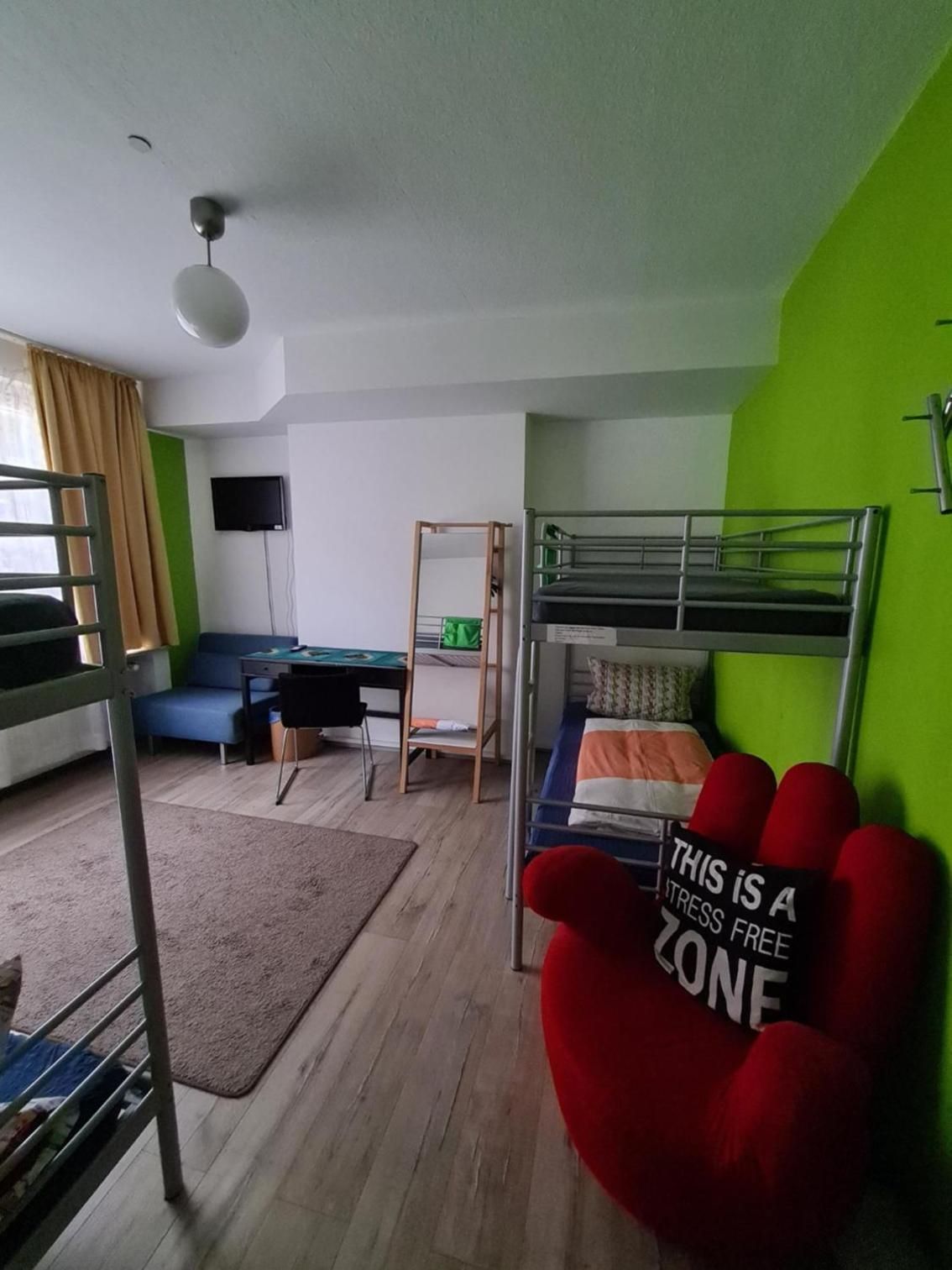 Una habitación con literas, un escritorio, una silla y una televisión.
