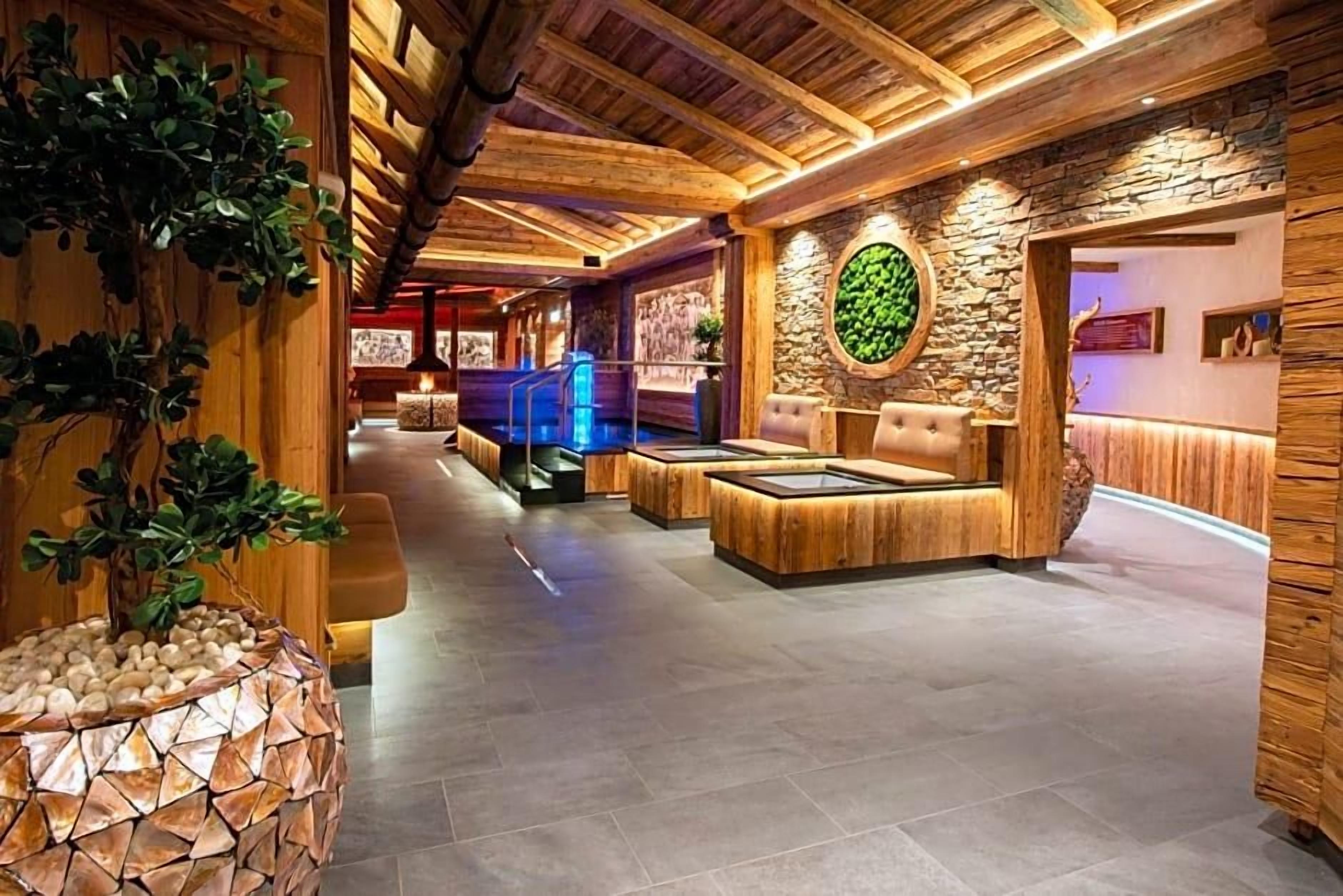 Ein Wellnessbereich mit Holzbalken, einer Steinwand und einer Rezeption.