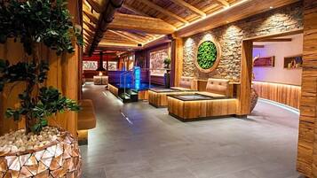 Ein Wellnessbereich mit Holzbalken, einer Steinwand und einer Rezeption.