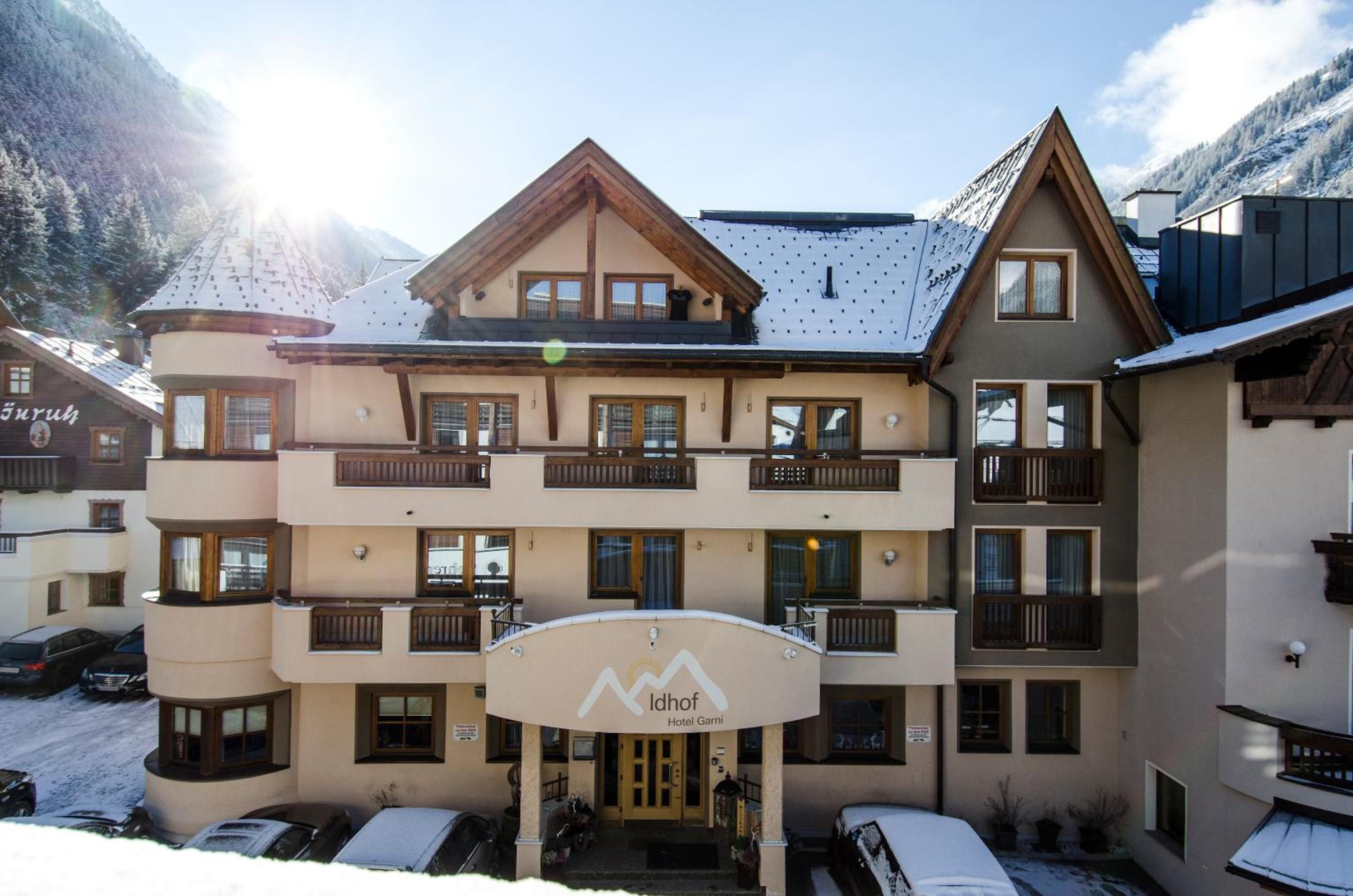 A multi-story hotel with a ski resort facade, balconies, and a covered entrance.