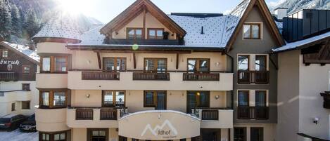 A multi-story hotel with a ski resort facade, balconies, and a covered entrance.