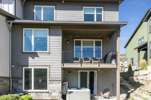 A two-story building with a balcony, large windows, and outdoor seating. - Pet Friendly! New beautifully decorated! Hot tub, Arcade Minutes from Deer Valley and Main Street (Hideout)